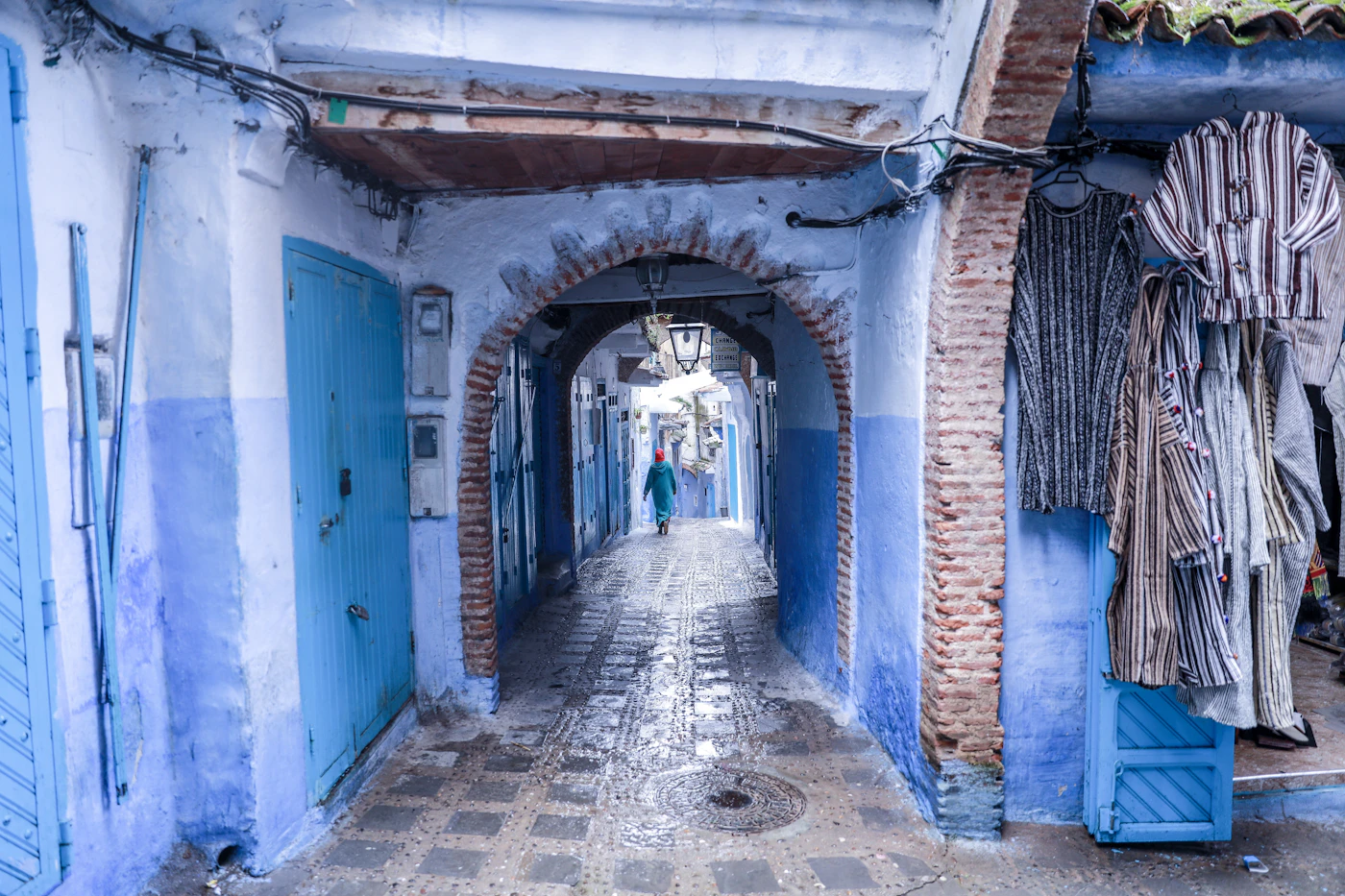 A shaded blue passage with an arched doorway