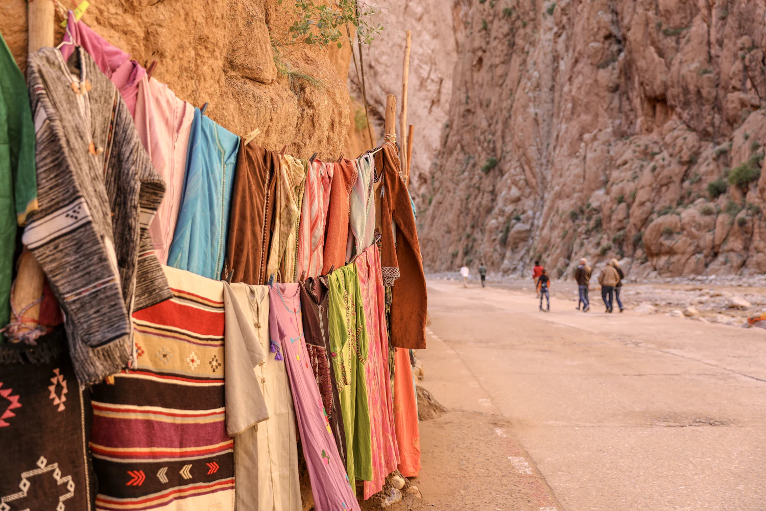 Towering red cliffs of the Todra Gorge above the valley road