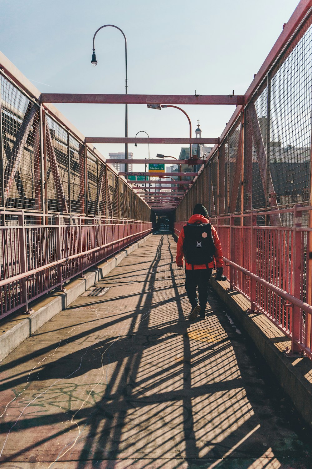 a person walking across a bridge with a backpack