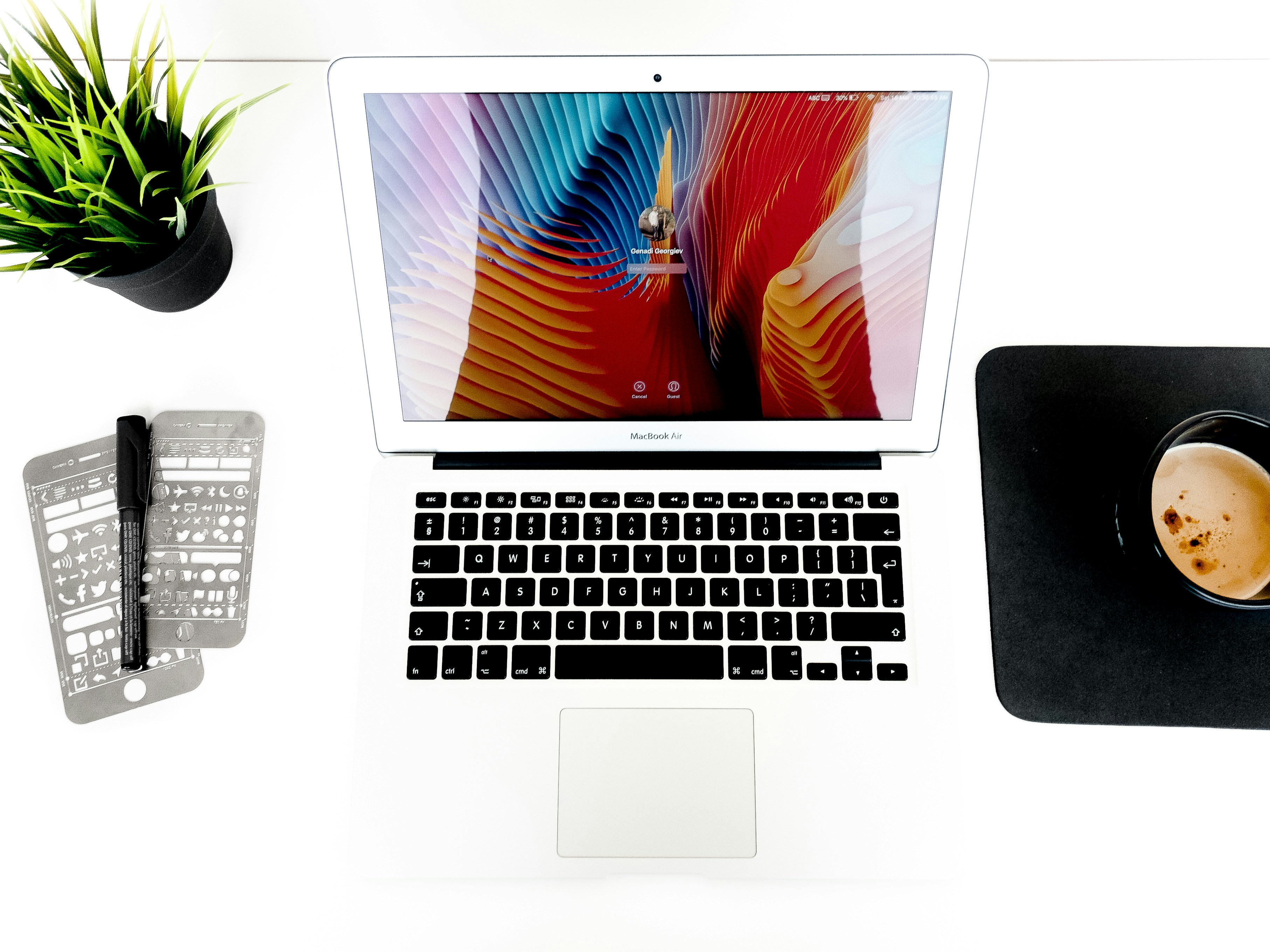 MacBook Air di antara spidol dan cangkir kopi