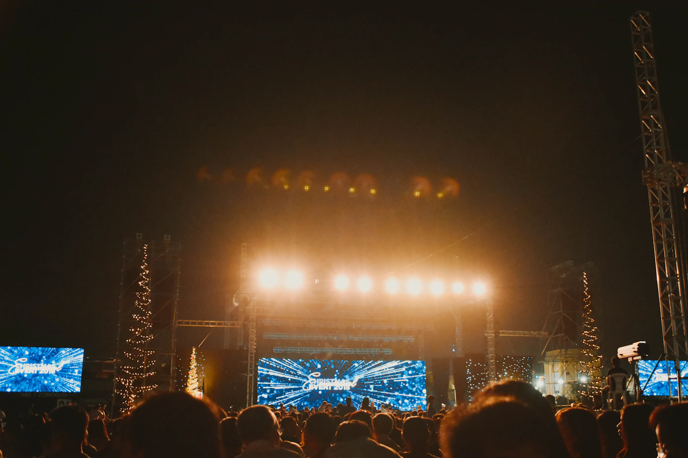 Crowd gathered in front of bright stage lights at a live show.