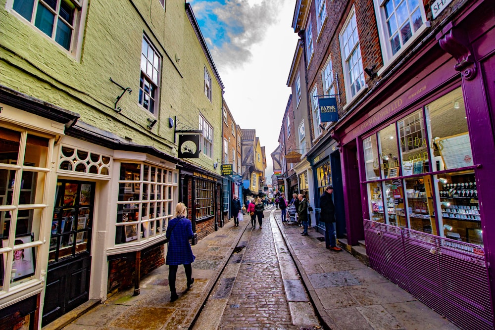 people walking in between stores under cloudy sky during daytime