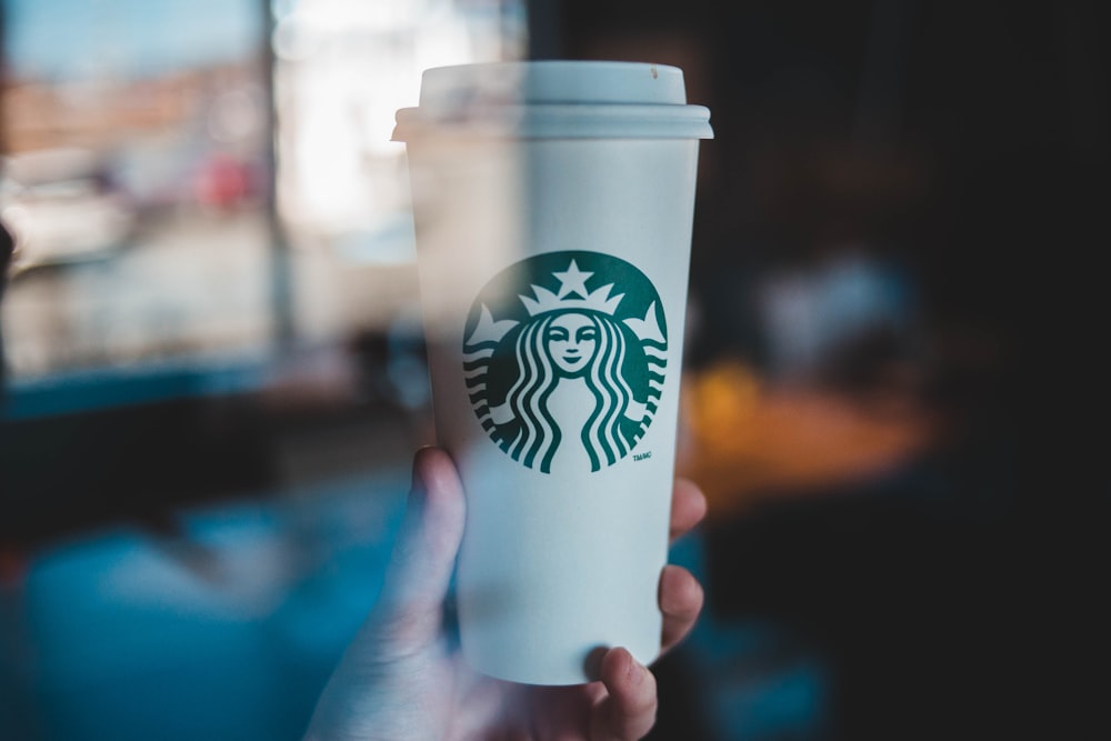 person holding Starbucks coffee cup