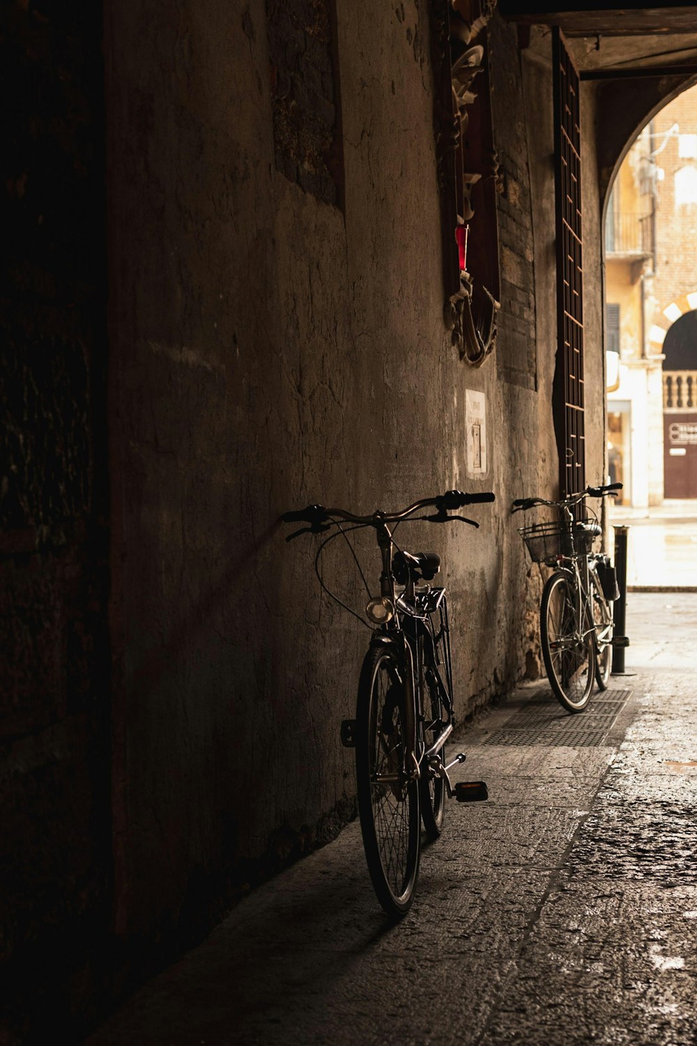 two black bicycles parked at wall during daytime