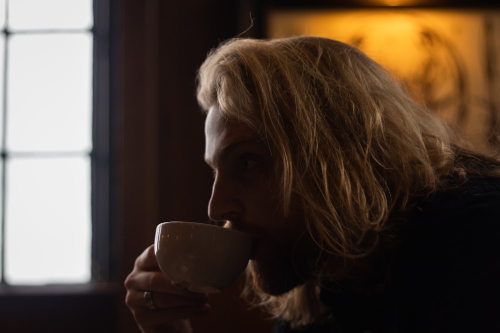 selective focus photography of man sipping coffee