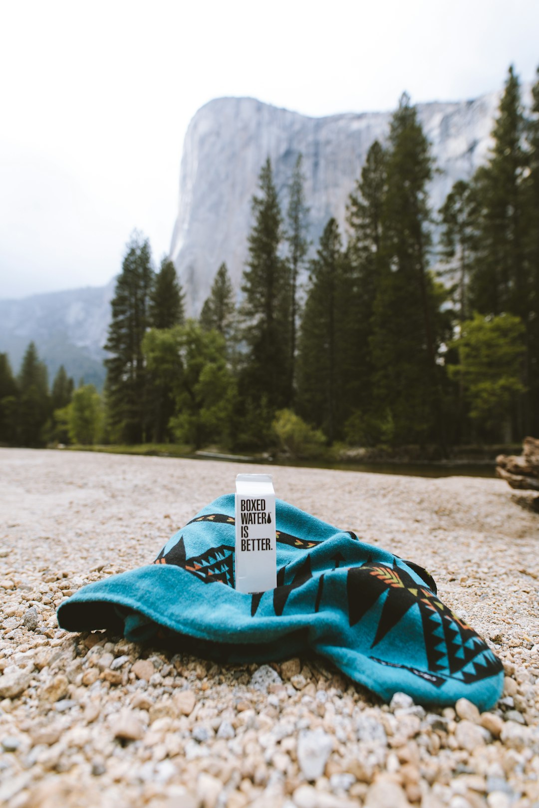 A blue garment with a Boxed Water carton in front of El Capitan in Yosemite