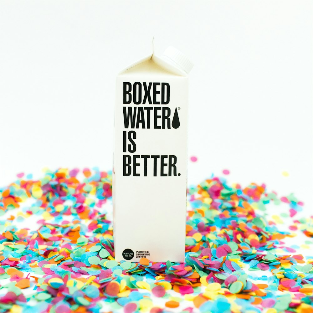A Boxed Water carton sits on top of confetti