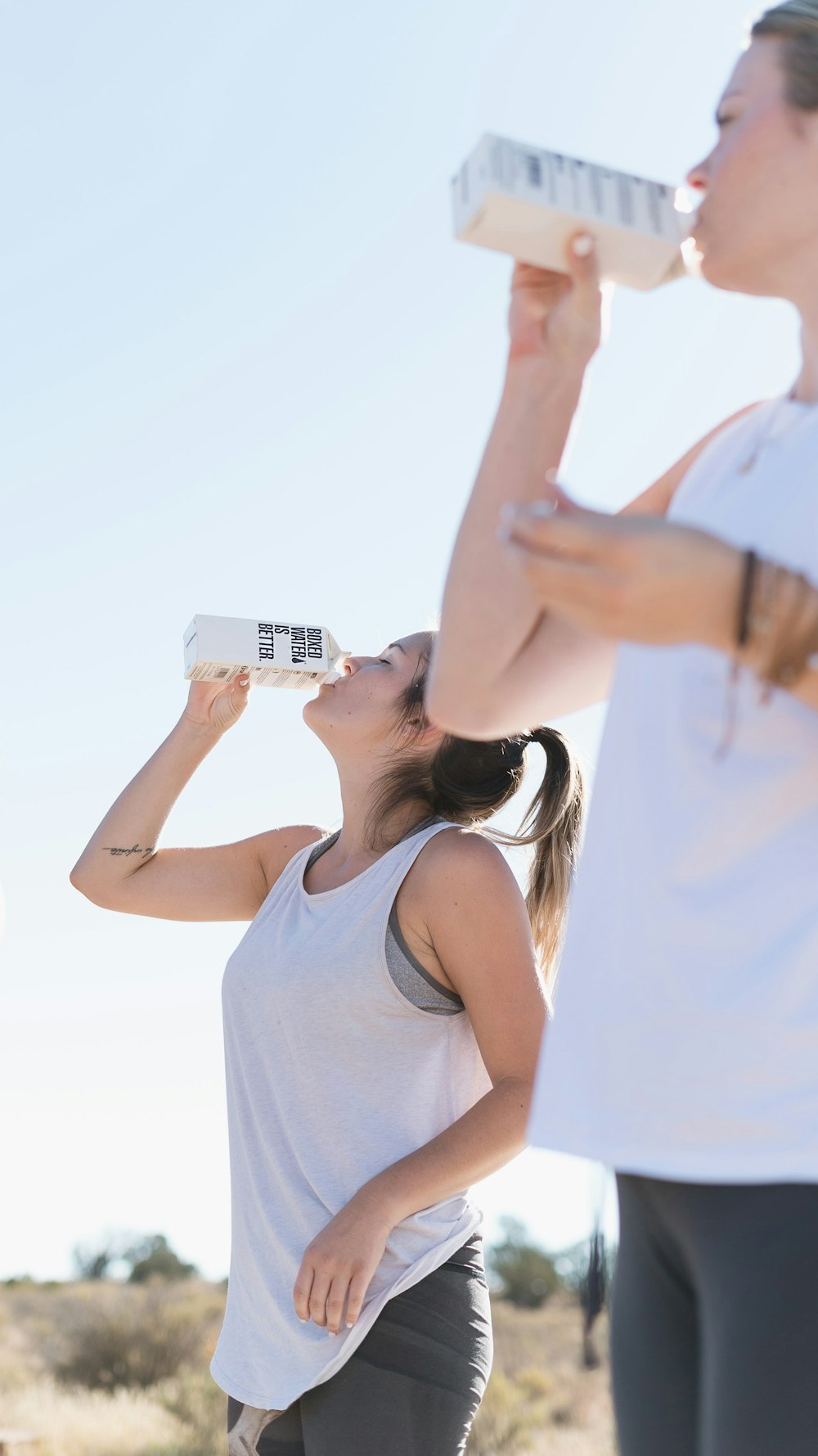 Zwei Frauen trainieren und trinken Wasser in Schachteln