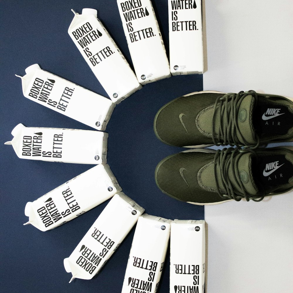 A pair of Nike running shoes next to an arrangement of Boxed Water cartons