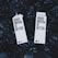 Two cartons labeled 'Boxed Water Is Better' rest on a bed of smooth, dark stones. The cartons are white and feature bold black text, emphasizing an eco-friendly message.