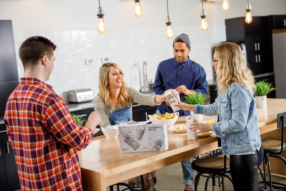 A group of people share Boxed Waters over a kitchen table