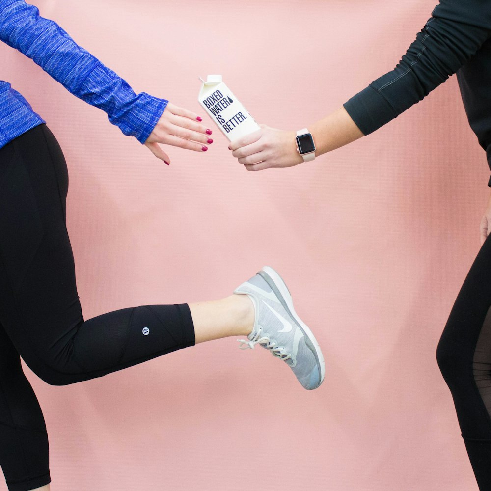 Two people running pass a Boxed Water carton