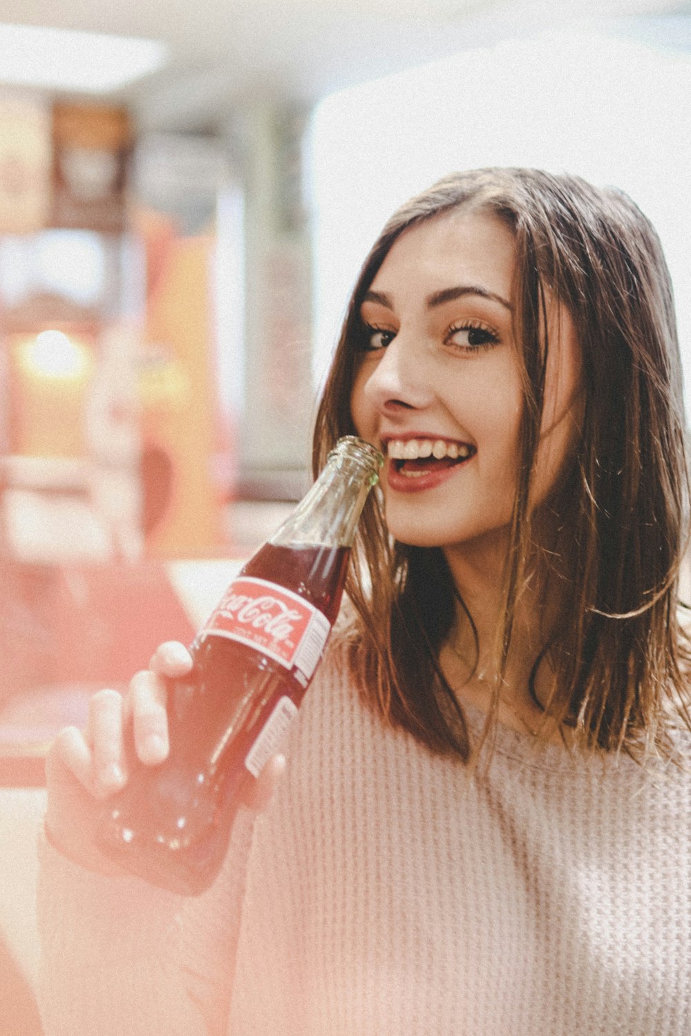 woman holding Coca-Cola bottle