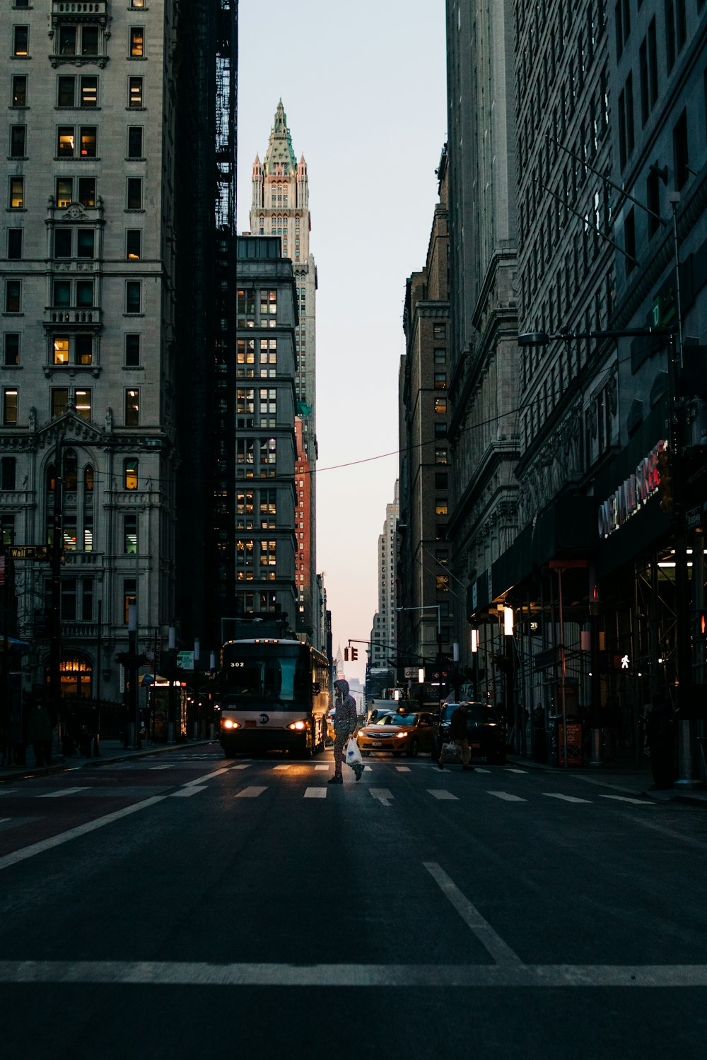 bus riding on street surrounded by high rise buildings