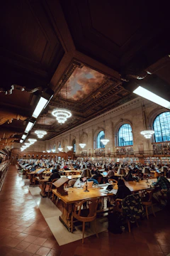 Library interior with students studying and organizing books.