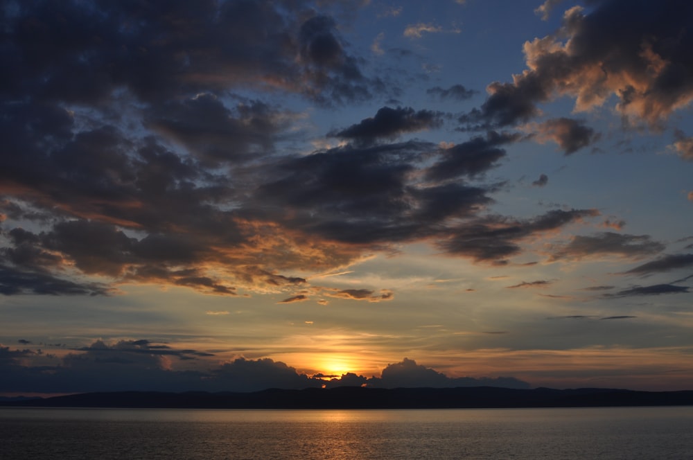 body of water under cirrus clouds