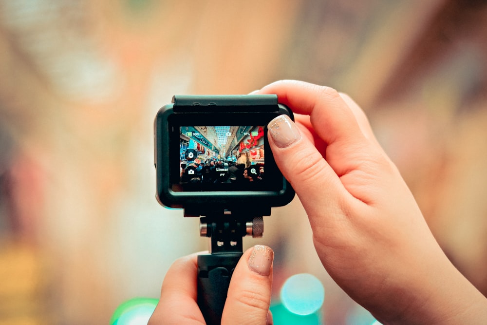 selective focus photography of person taking photo of people gathering outside building