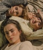 three women lying on white surface