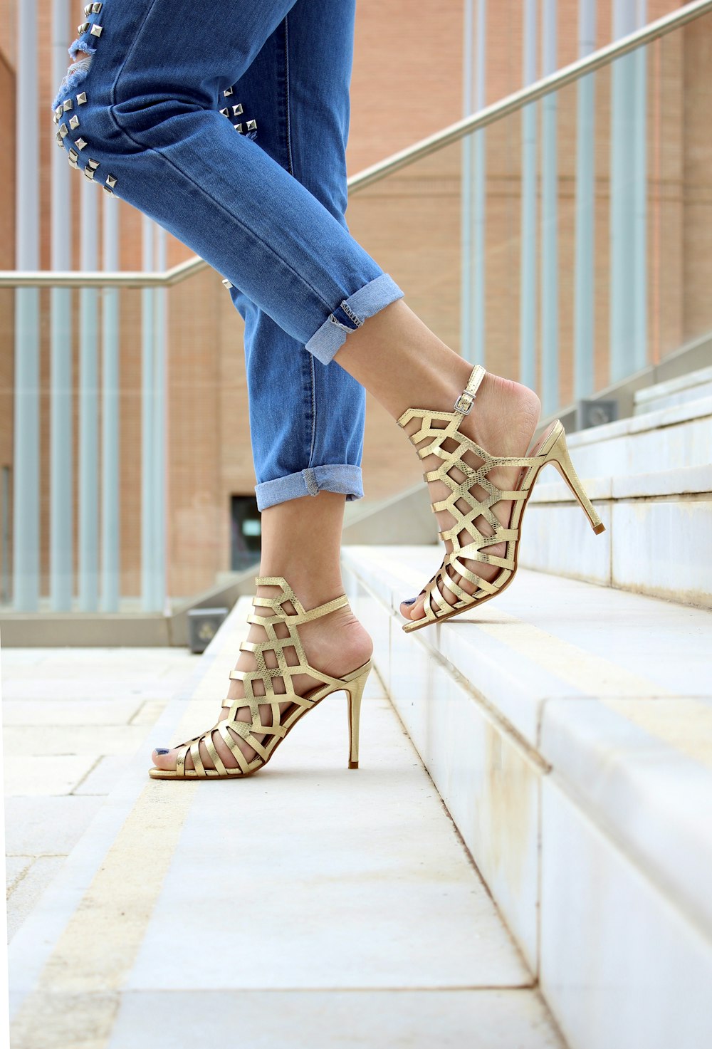 woman wearing brown leather heeled sandals walking on staircase