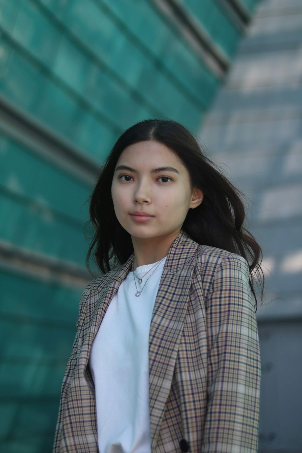 woman in white shirt and brown plaid blazer