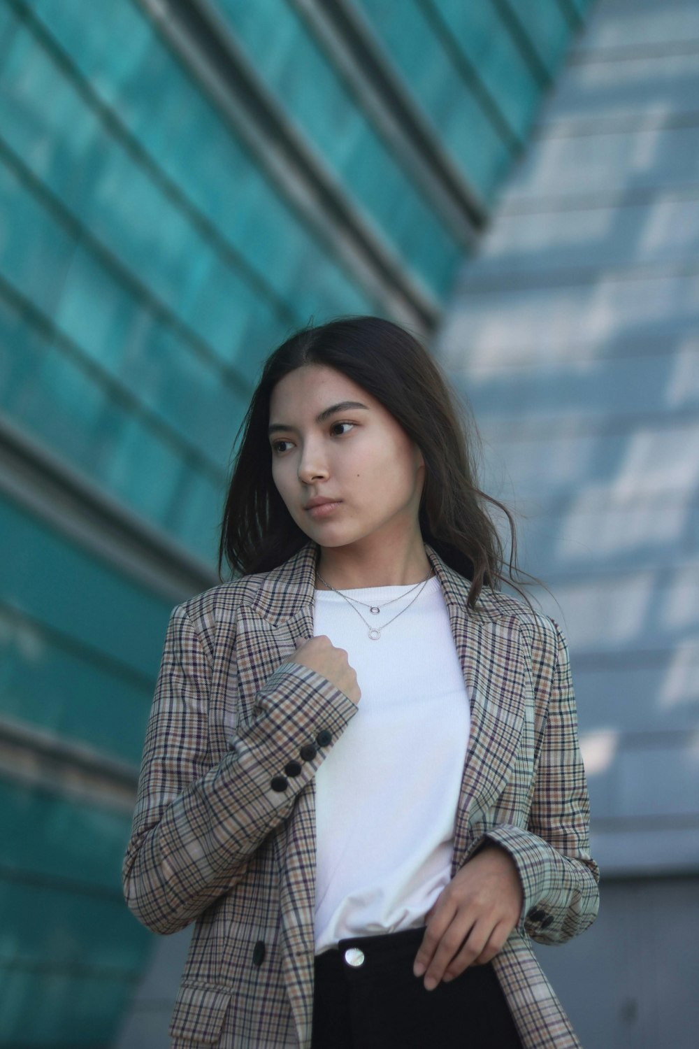 woman wearing brown plaid blazer across building