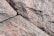 A close-up view of rough, textured granite stones with visible grain and natural color variations. The stones are arranged with visible gaps in between, highlighting their irregular, natural formation.