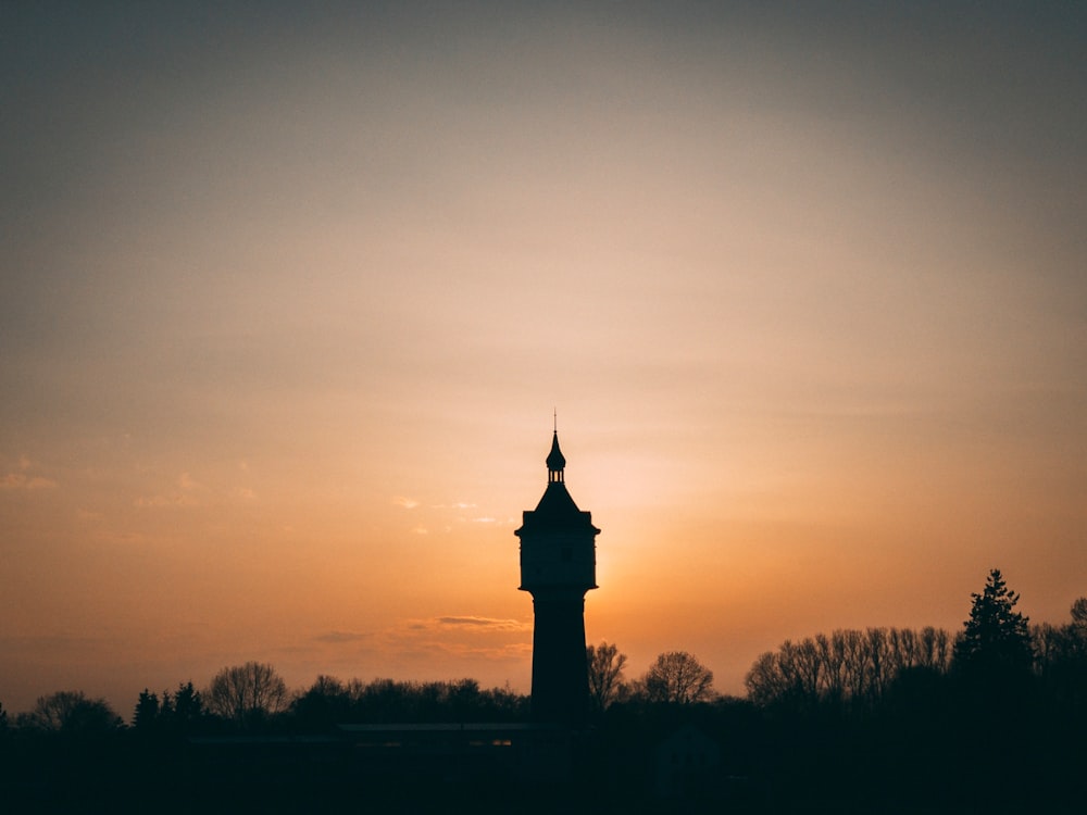 silhouette of tower on gold sky during dusk