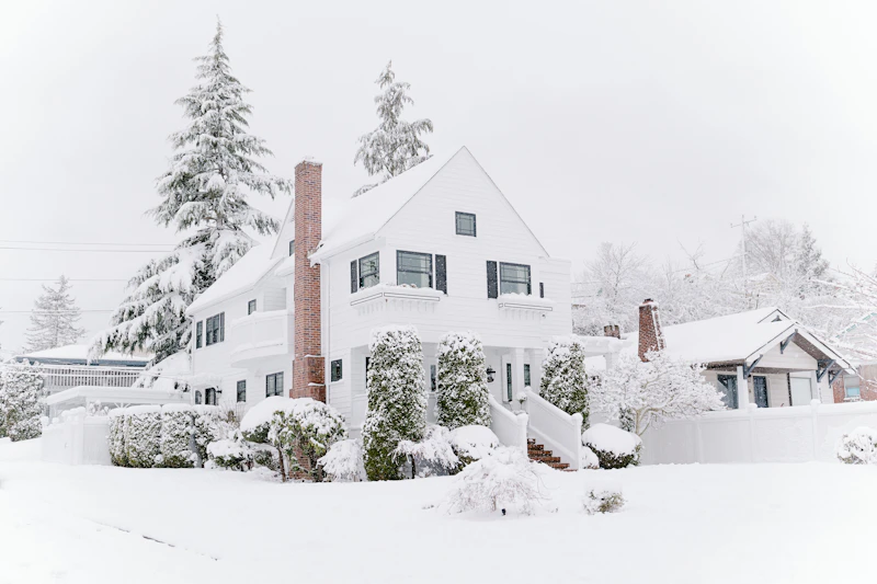 Snow-covered houses under a wintry sky, illustrative photo
