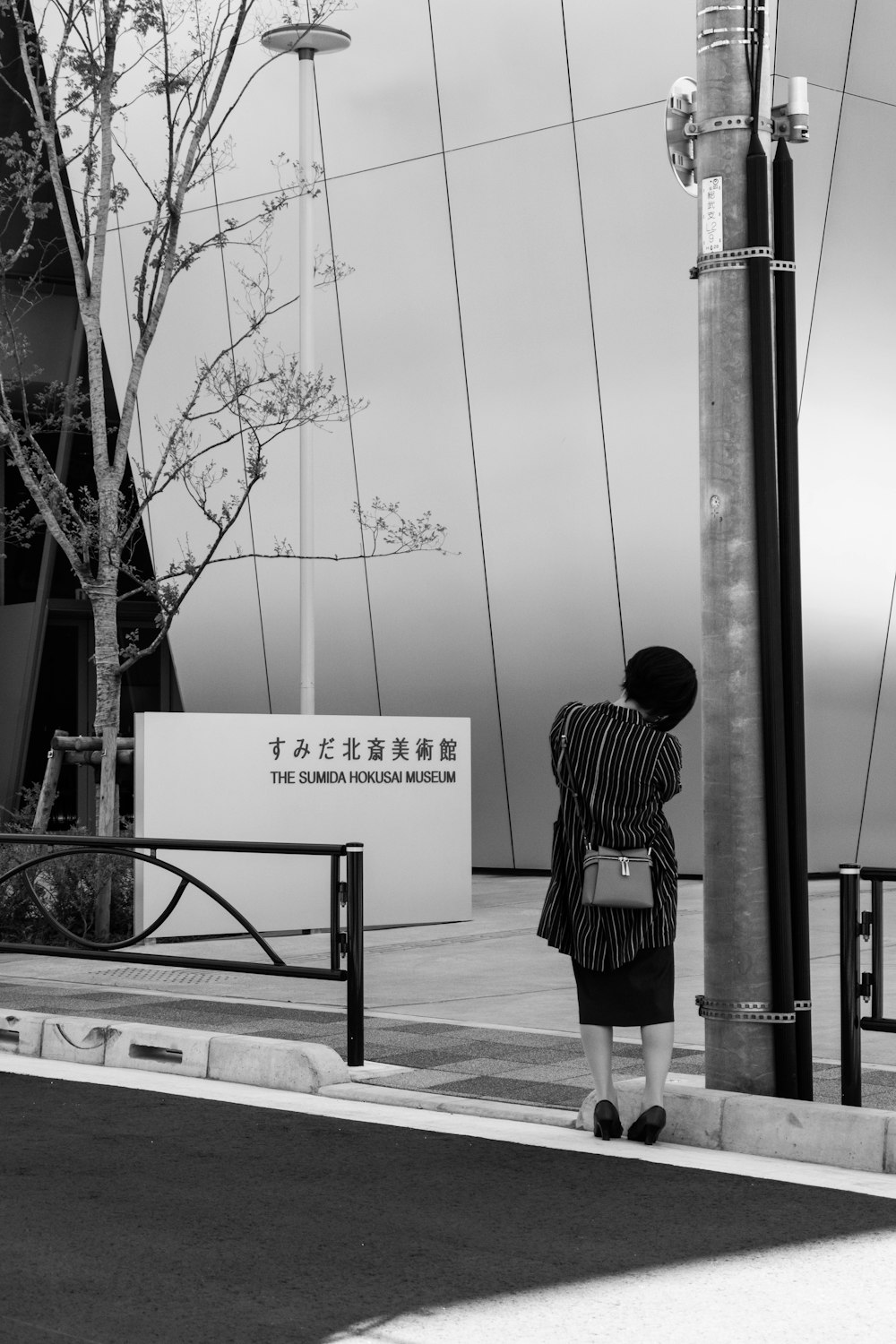 woman standing near street post