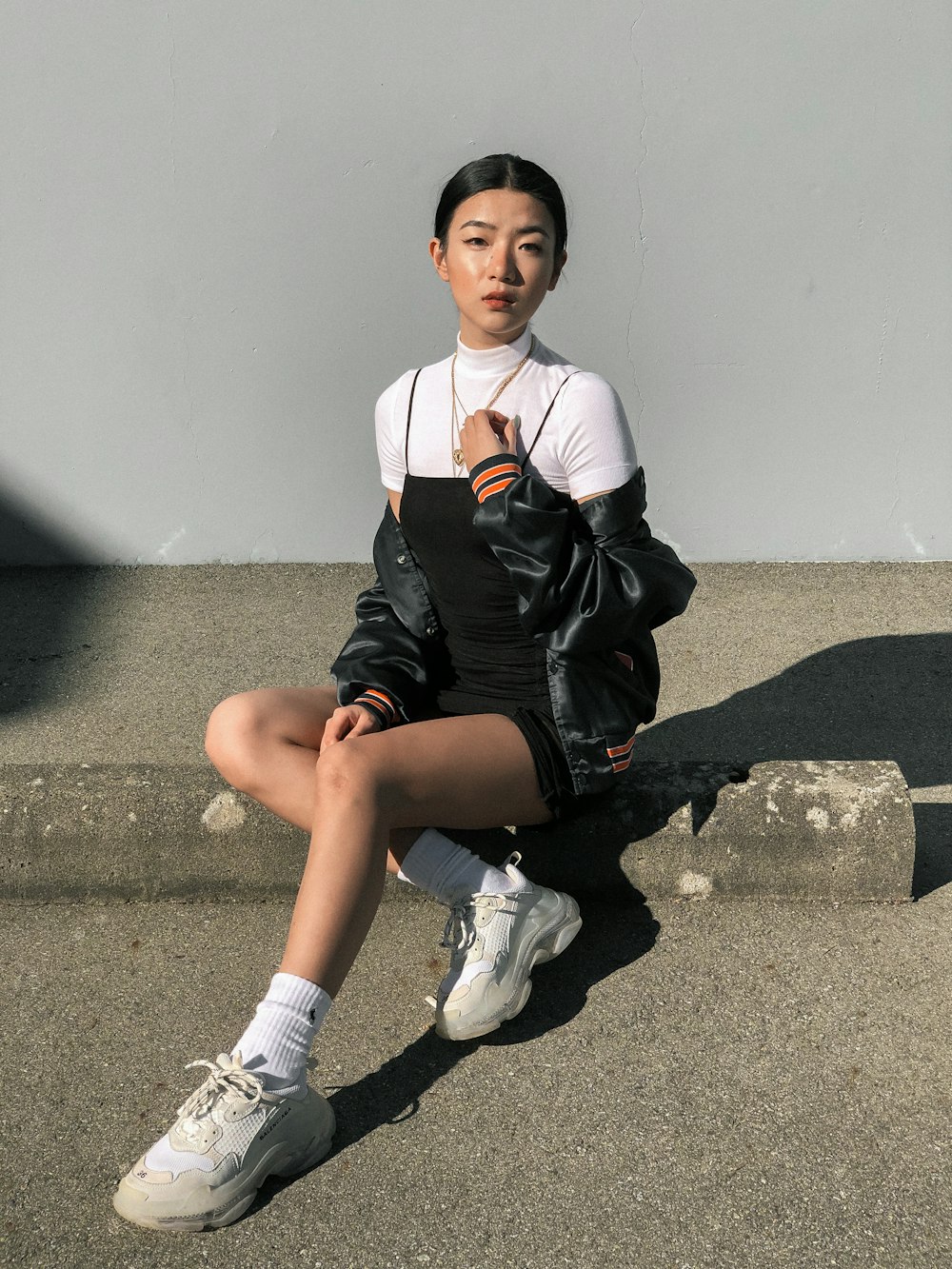 woman sitting on gray concrete surface