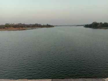 A serene river flowing through untouched natural landscape under a calm sky.