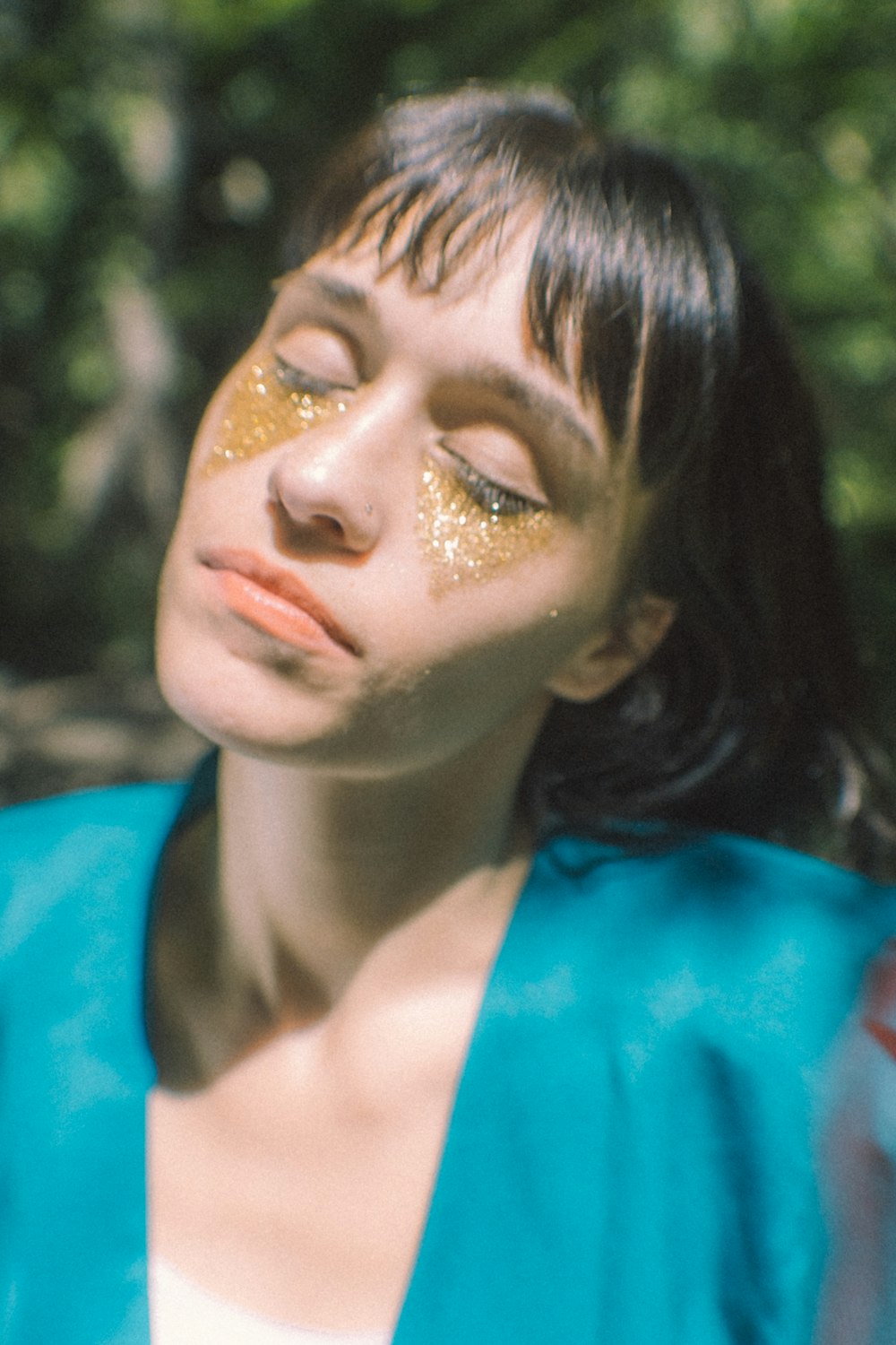 woman in blue top and glittered eyes