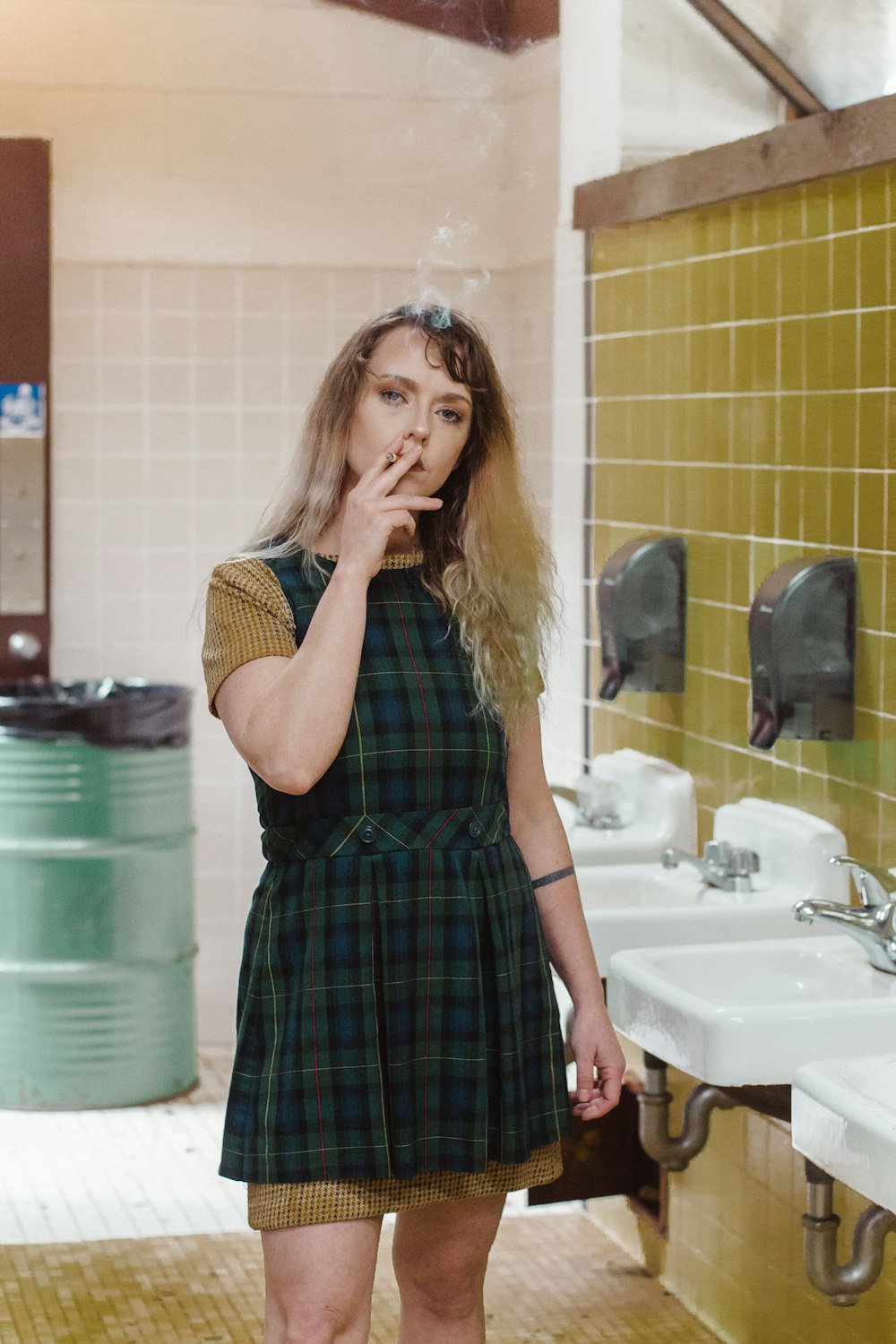 woman smoking cigarette inside bathroom