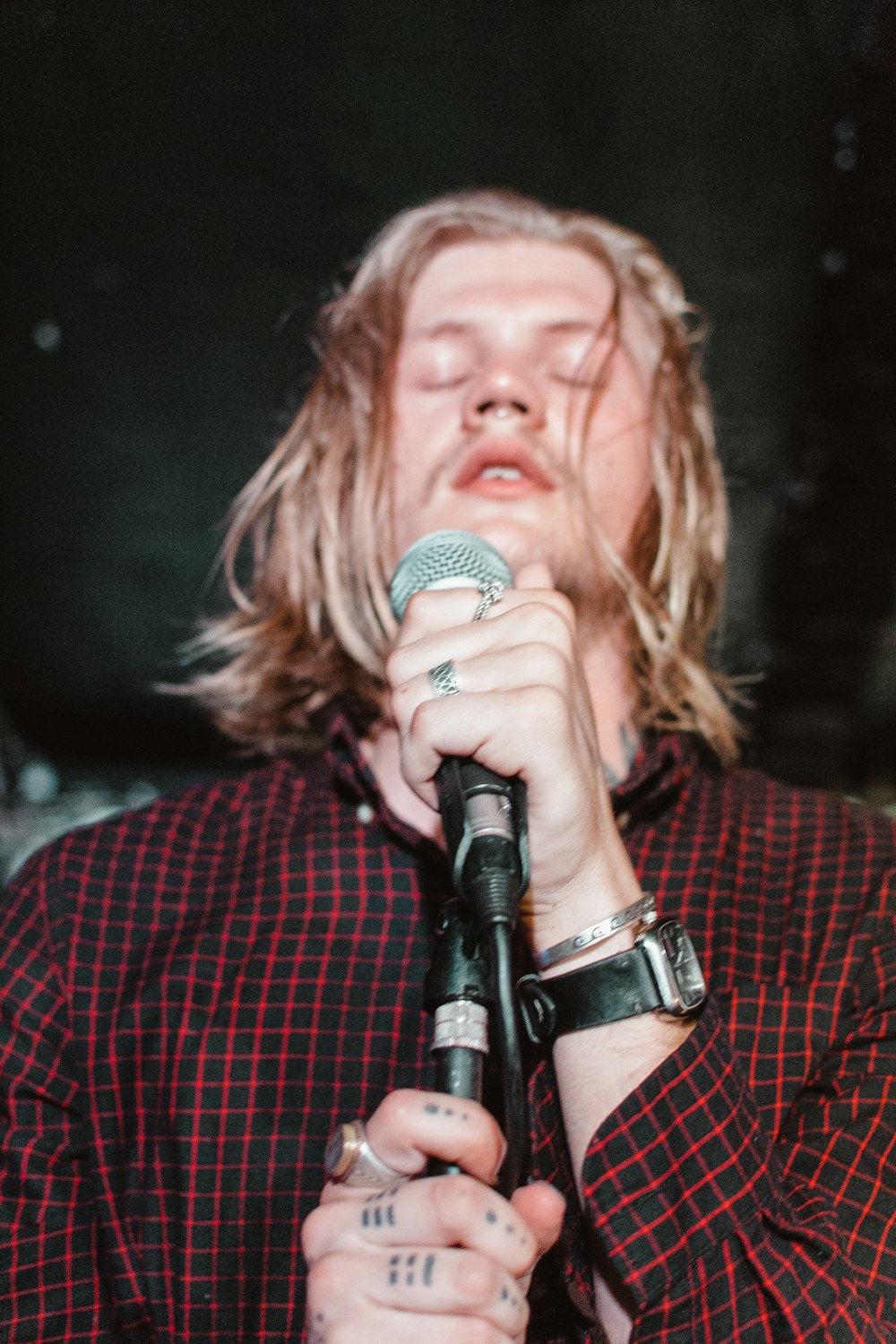 man holding black microphone with eyes close