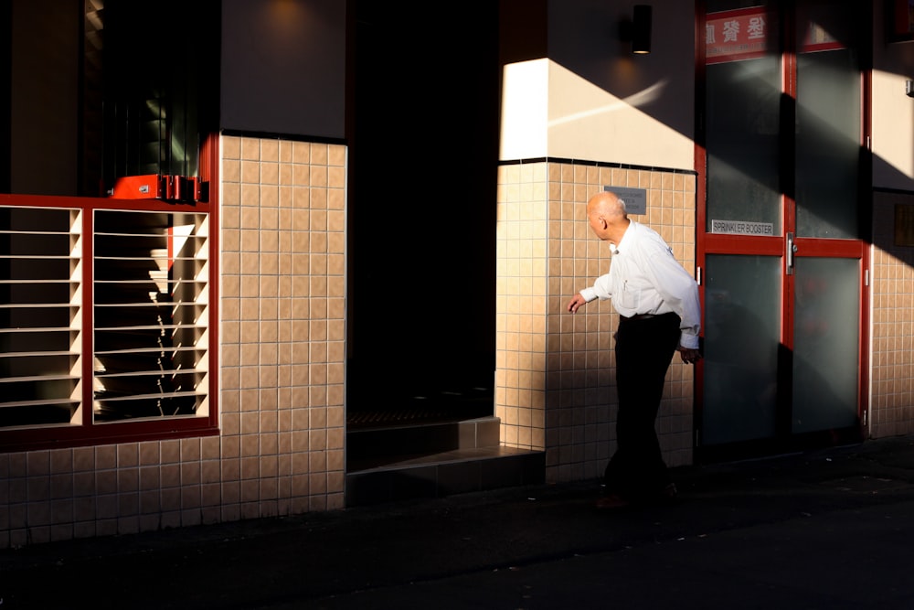 man walking in front of brown wall