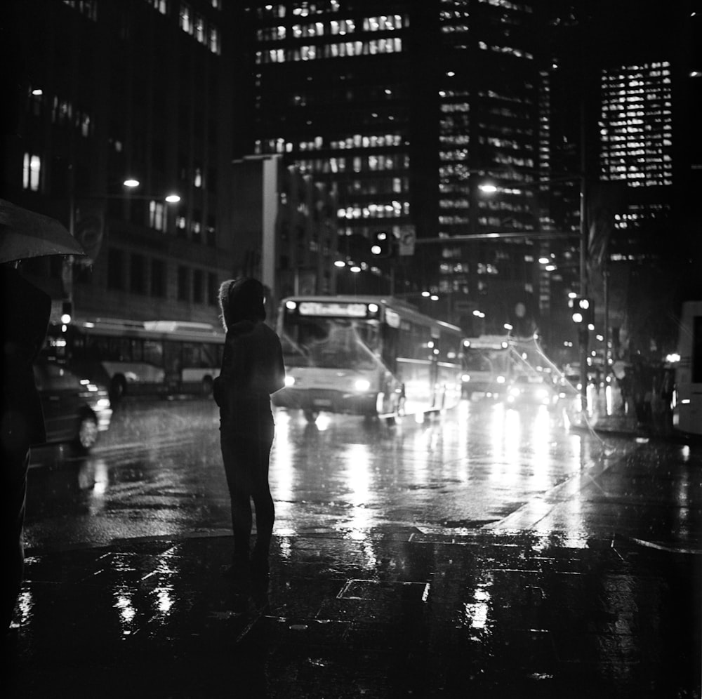 person standing on road in grayscale photography