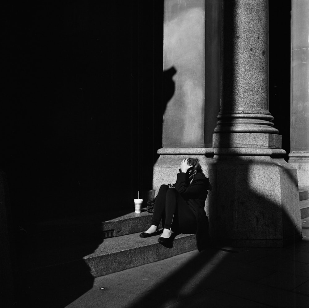 grayscale photo of woman sitting on stairs