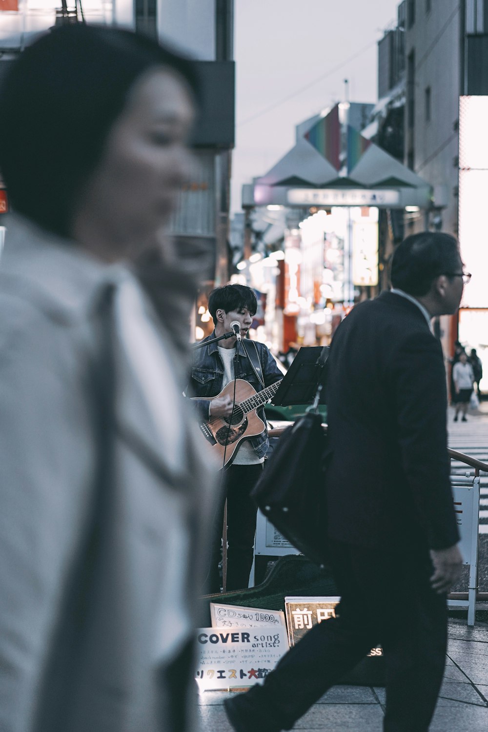 selective focus photography of man playing guitar on street