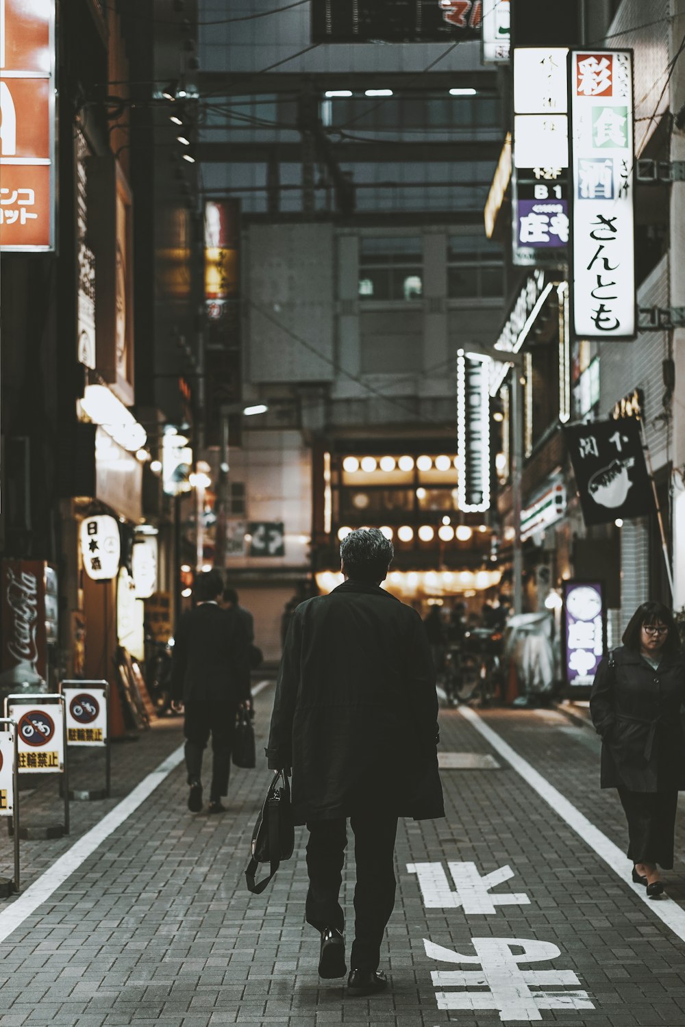 man walking on street surrounded by buildings