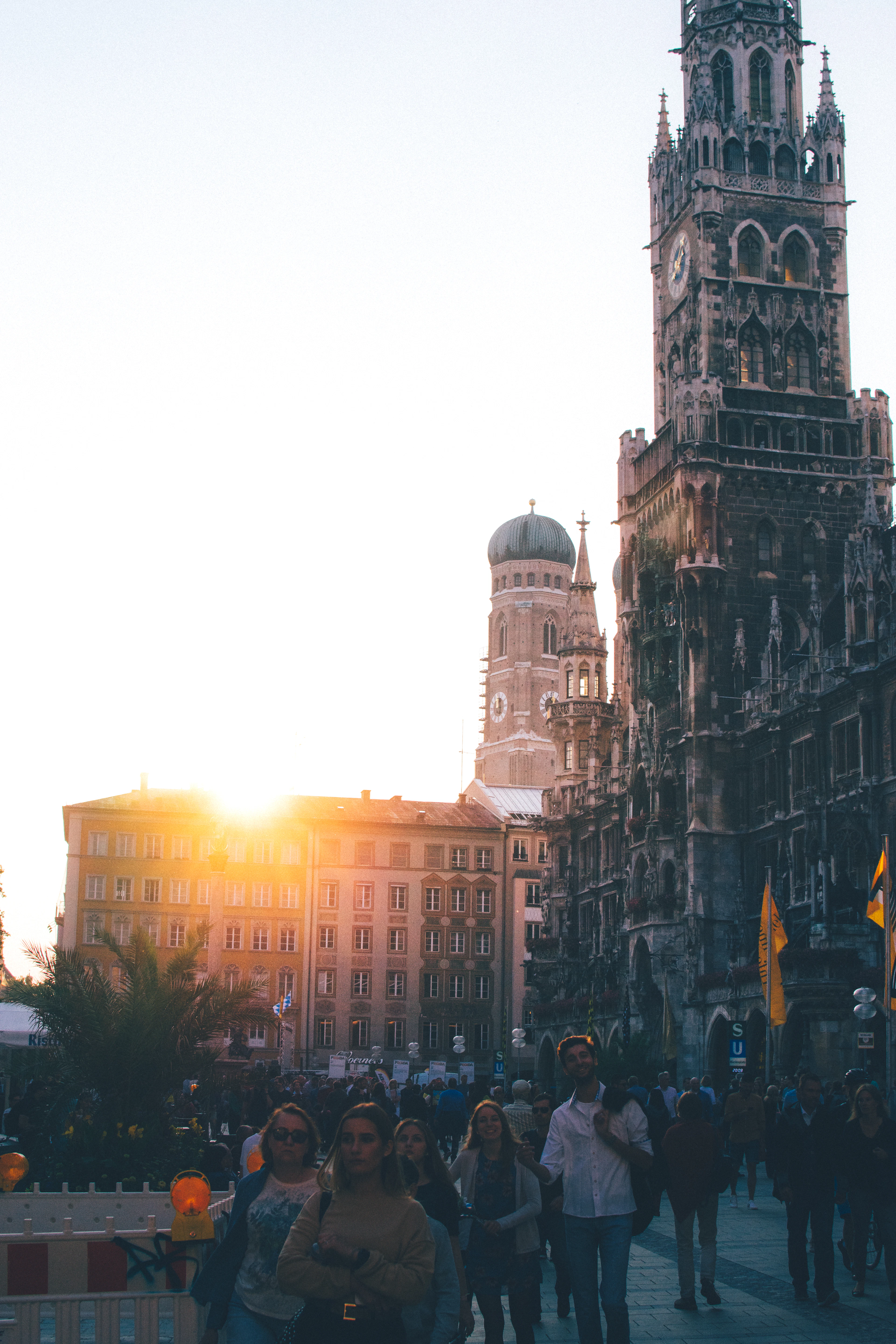 The twin domes of Munich's Frauenkirche behind the spires of the Neues Rathaus at sunset