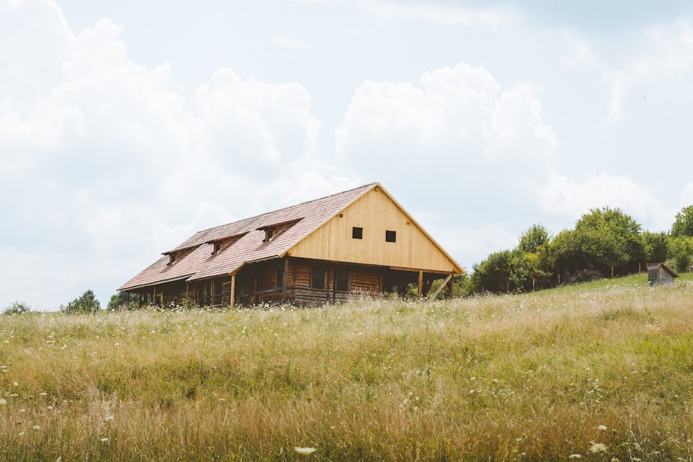 brow and beige barn surrounding grass field