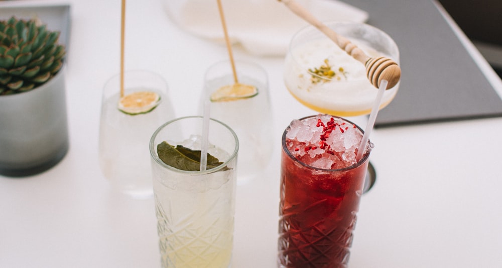 five drinking glass filled with liquid