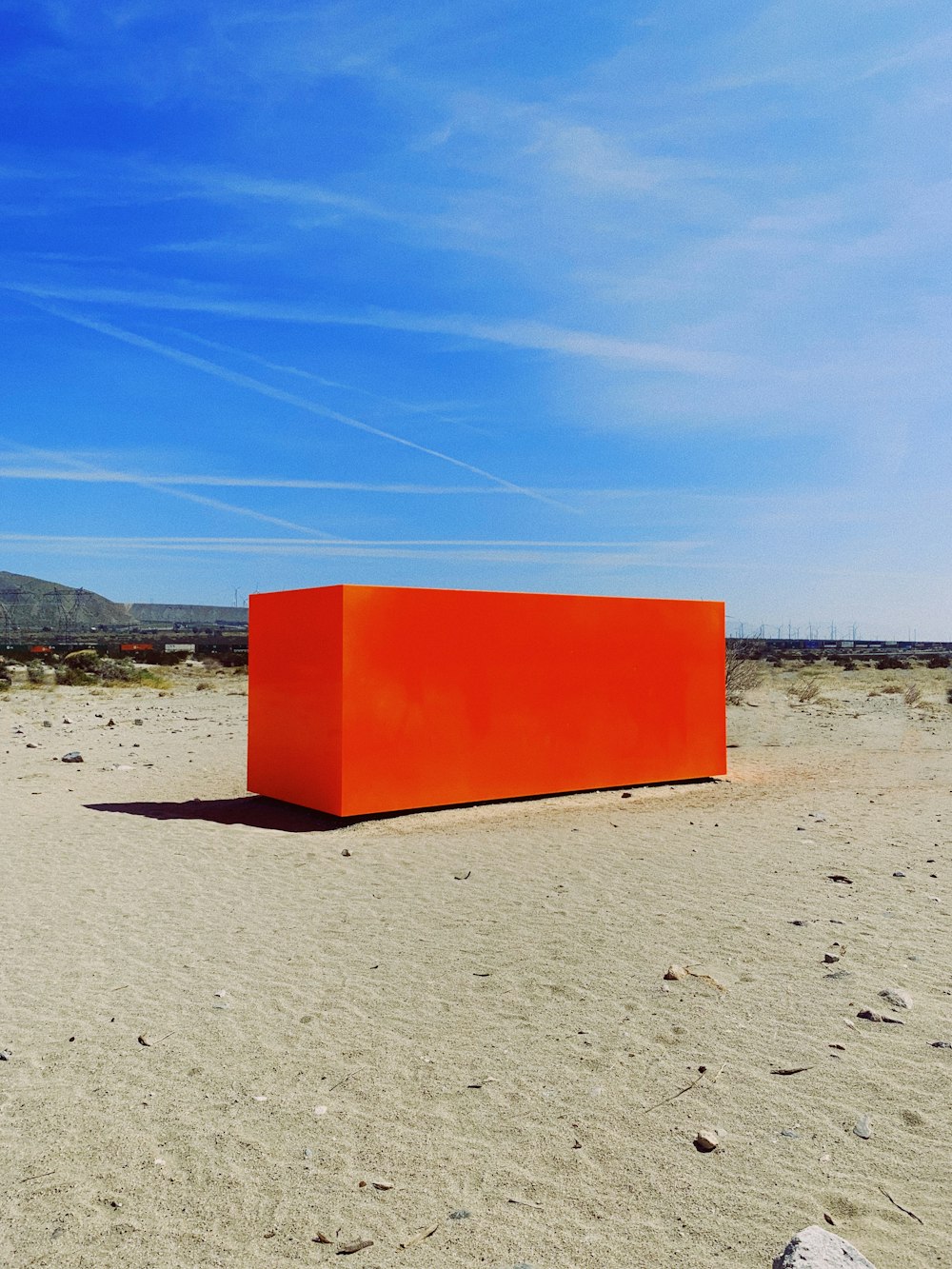 Conteneur rectangulaire rouge sur le sable à l’extérieur pendant la journée