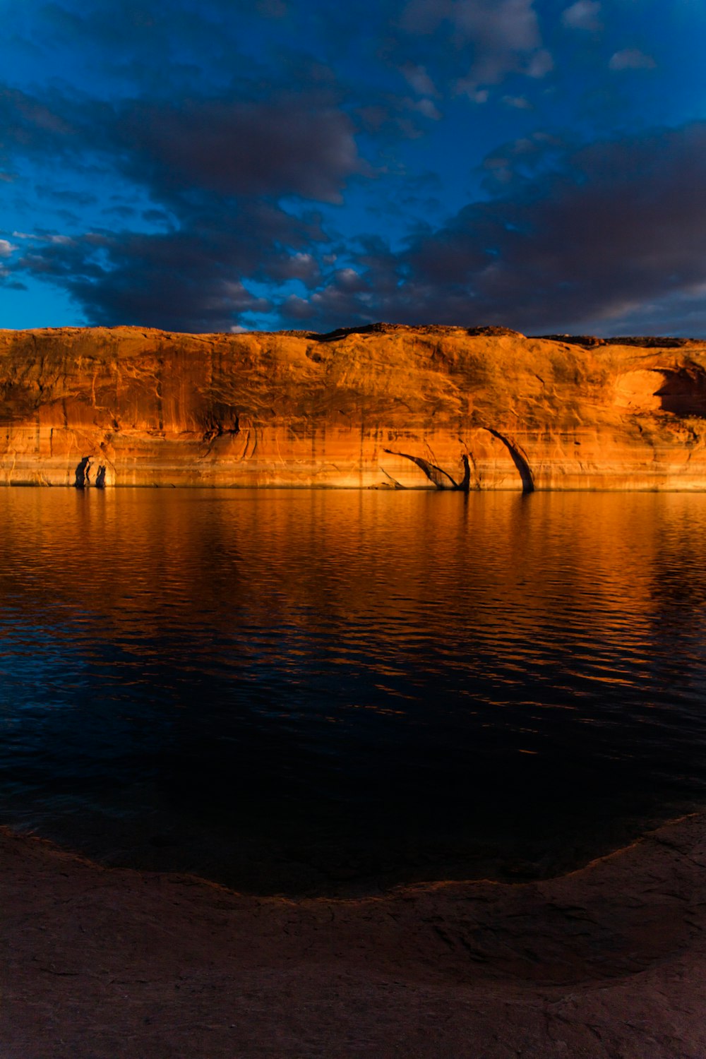 brown rock formation beside body of water during daytime