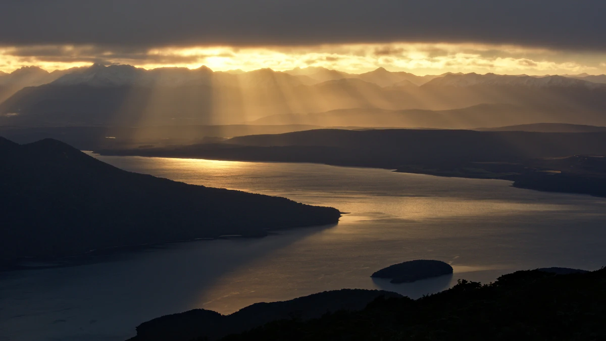 Sunbeams breaking through cloud over Lake Te Anau and the Fiordland mountains, seen from the Kepler Track