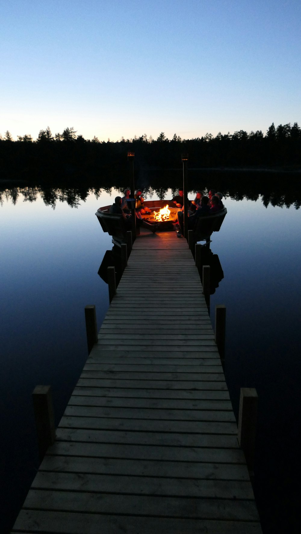 people on boardwalk surrounding bonfire