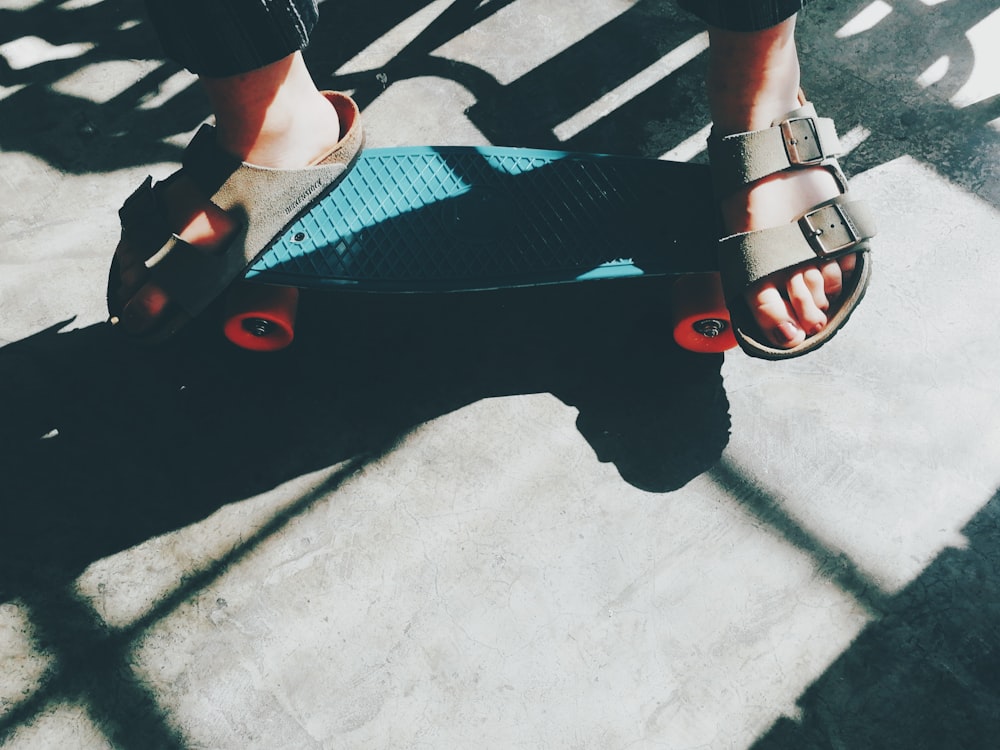 person riding teal cruiser penny board