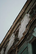 Close-up of a building facade with peeling paint showing wear and tear.
