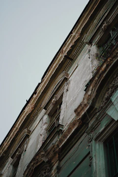 Close-up of a building facade with peeling paint showing wear and tear.