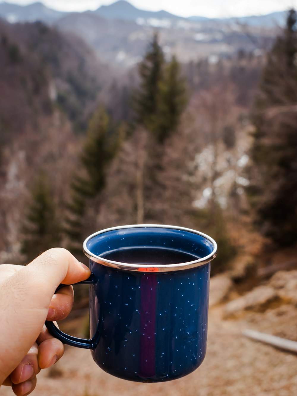 person holding blue ceramic mug